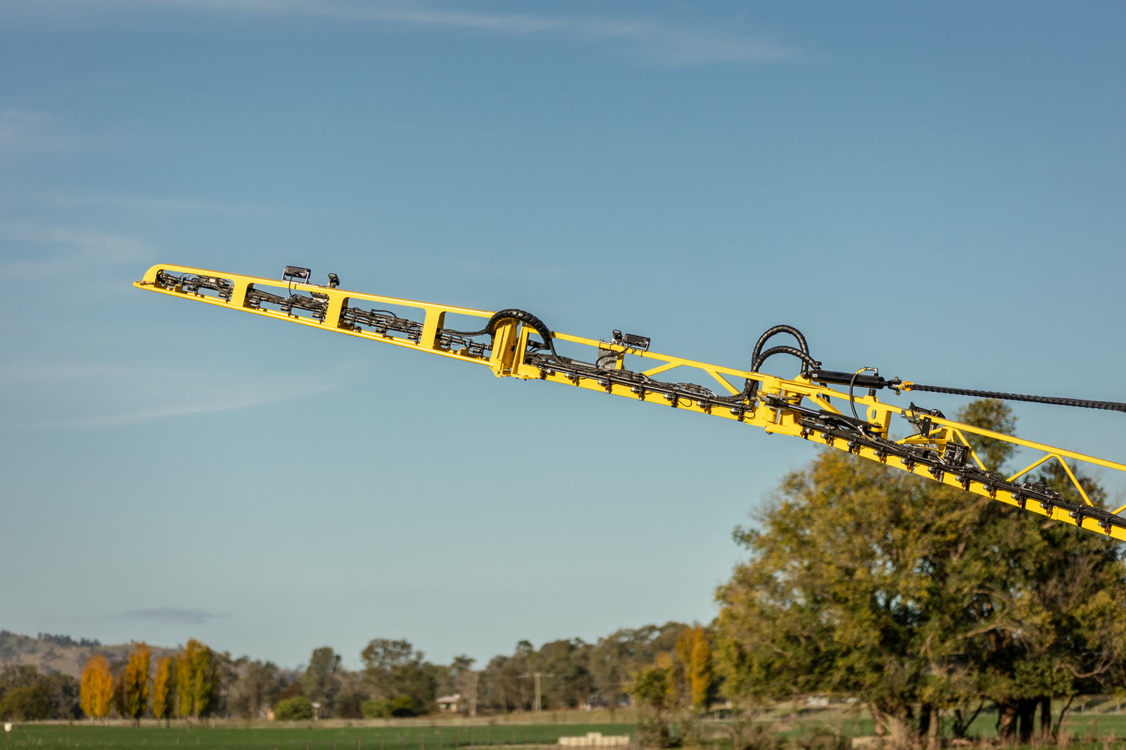 A yellow boom arm raised against a blue sky