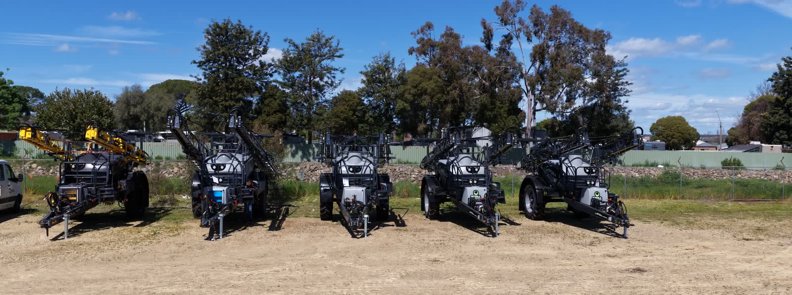 A row of Stoll boomsprays parked in the yard at Wagga Wagga with their booms folded