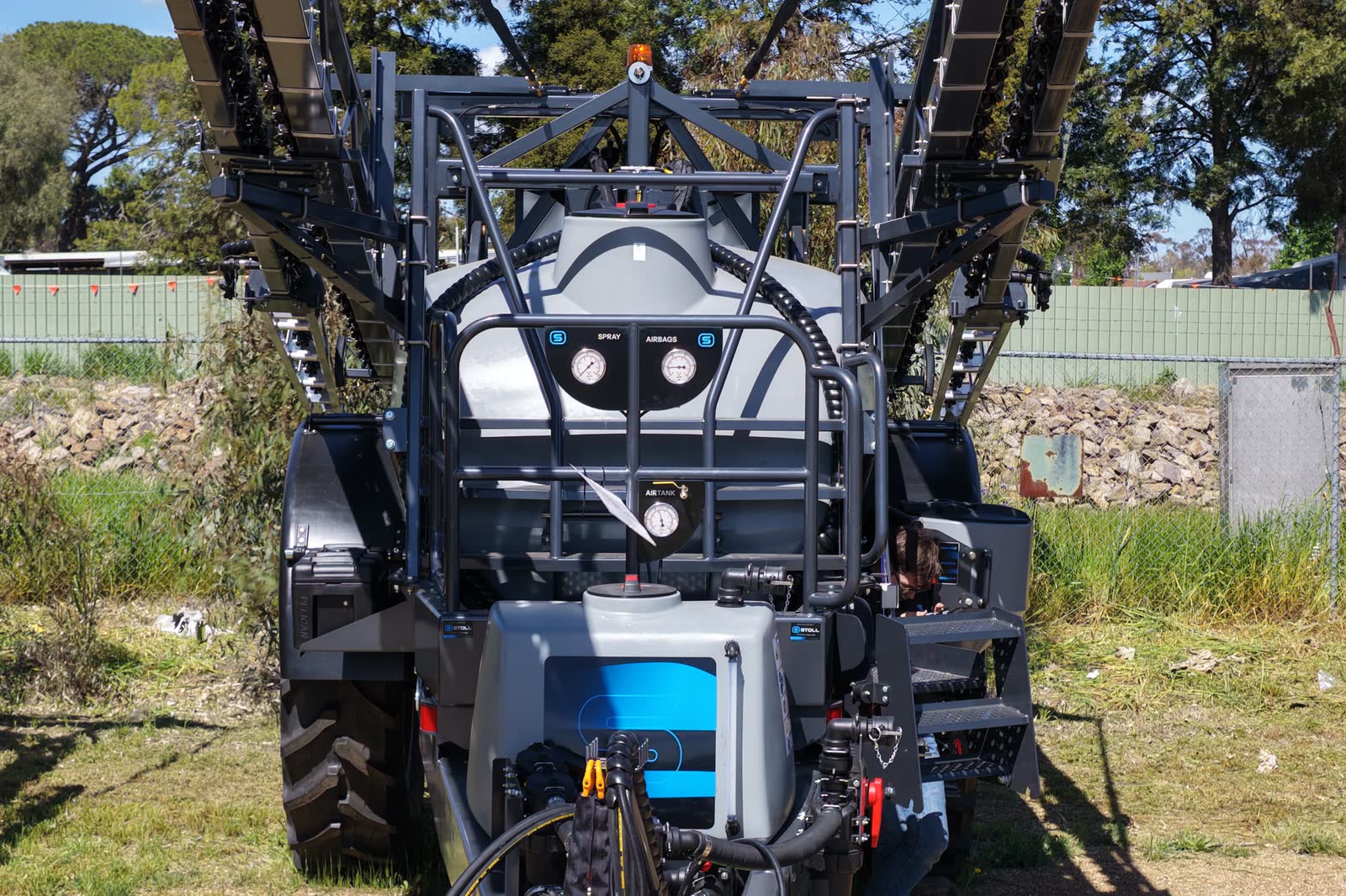 A Stoll boomspray head on, showing the induction hopper and gauges with the boom folded up